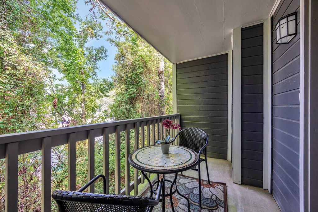 a patio with two chairs and a table on a balcony